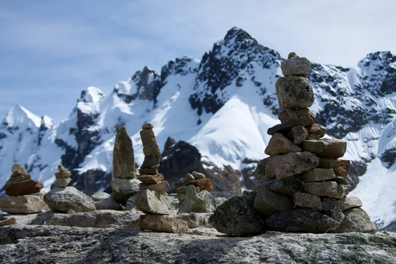 Apachetas de piedra en el paso de Salkantay con nevados al fondo